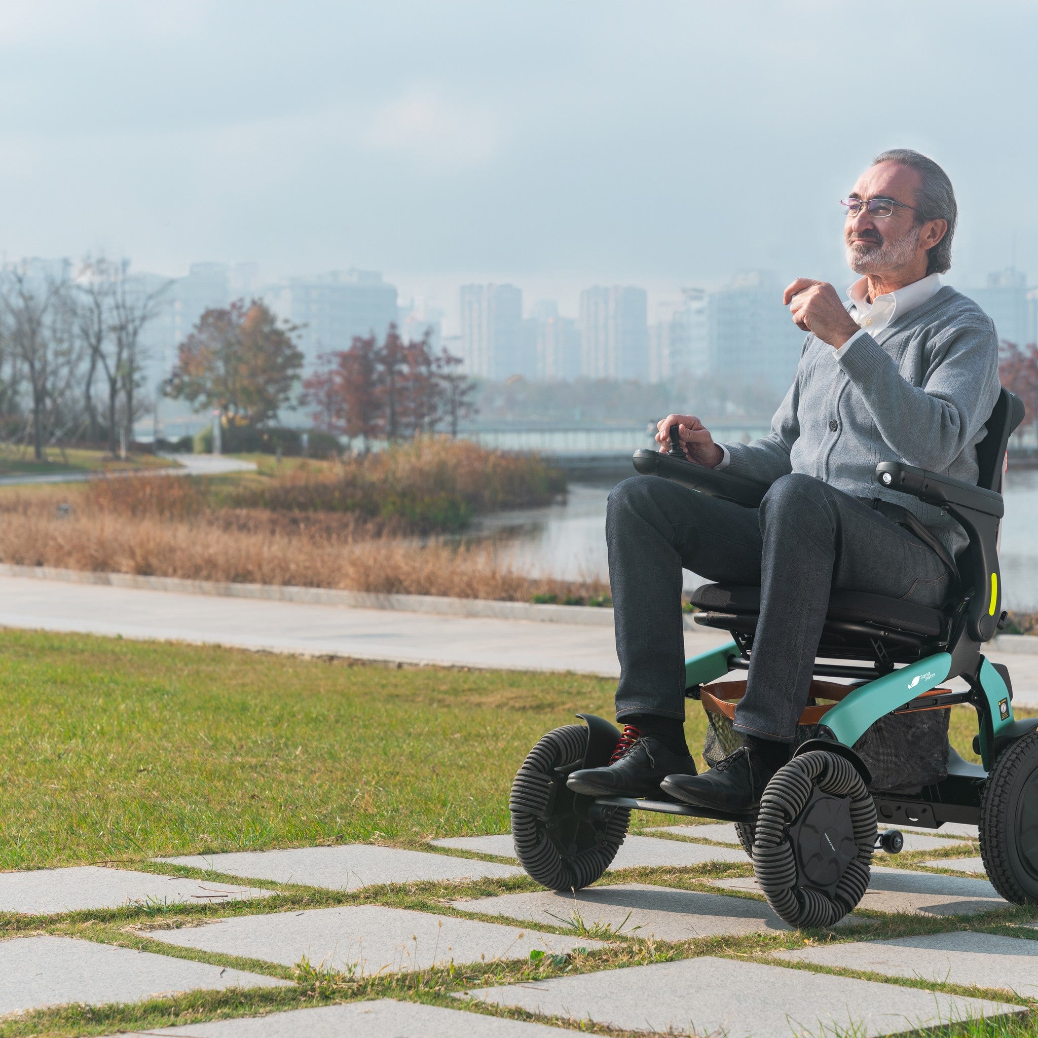 Elektrorollstuhl E60 Pro Outdoor im Park, fährt sicher über Rasen und Plattenweg